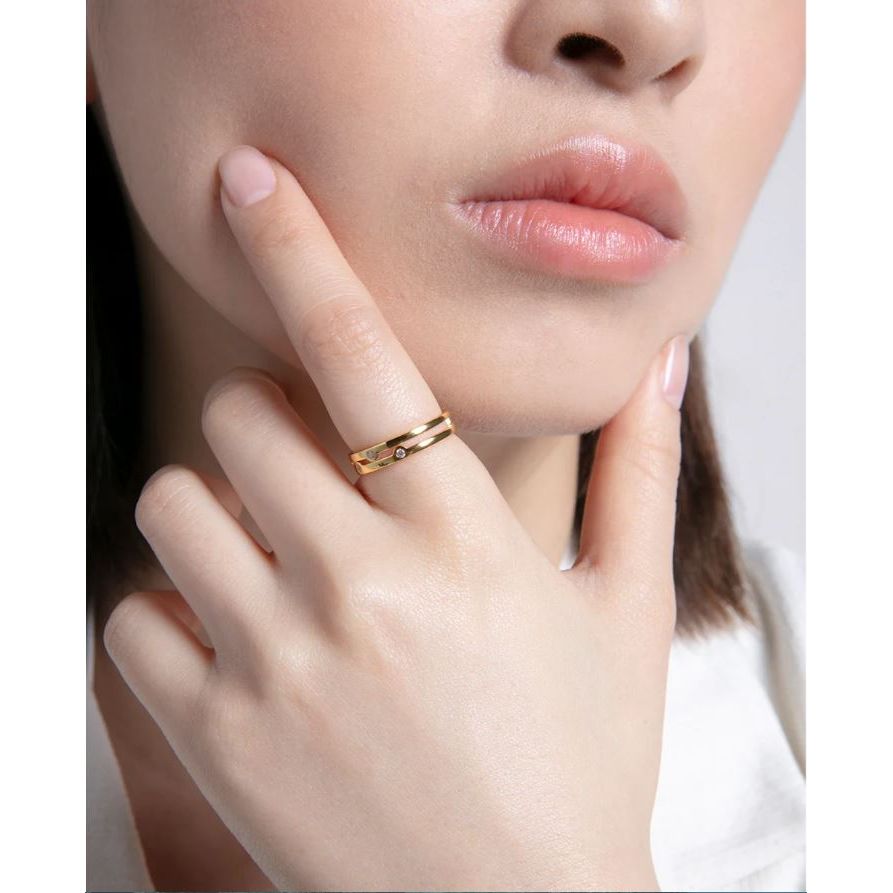 Woman wearing a stylish gold ring, showcasing fine craftsmanship and elegance. Perfect accessory for any occasion.