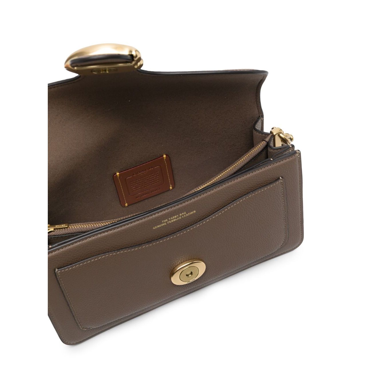 Interior view of the Coach Tabby 26 leather shoulder bag showing leather lining and zip compartment, focus on luxury craftsmanship.