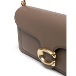 Close-up of Coach Tabby 26 leather shoulder bag with gold-tone hardware and textured leather surface.