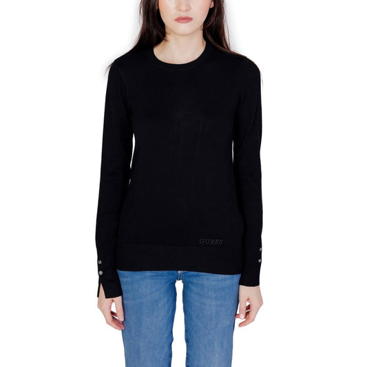 Woman wearing Guess Black Cotton Sweatshirt with buttons on cuffs and embroidered logo on hem.
