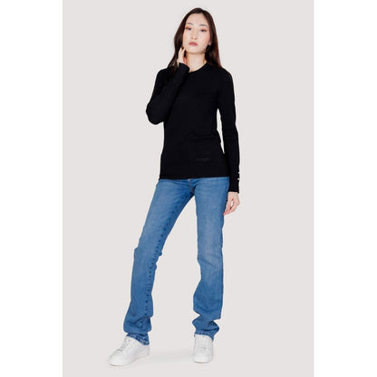 Woman wearing Guess Black Cotton Sweatshirt with jeans and white sneakers, showcasing comfort and style for any season.