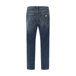 Dolce & Gabbana Jeans, back view showing five-pocket style, metal plaque with D&G monogram, straight fit, cotton with elastane, AW25.