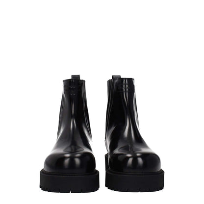 Front view of Givenchy Black Leather Ankle Boots with rubber sole and round toe design, showcasing front and back logos for a casual style.
