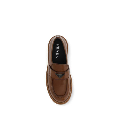 Top view of Prada Brown Calf Leather Bos Taurus Slip-On Loafers with iconic triangular plaque and carrarmate sole.