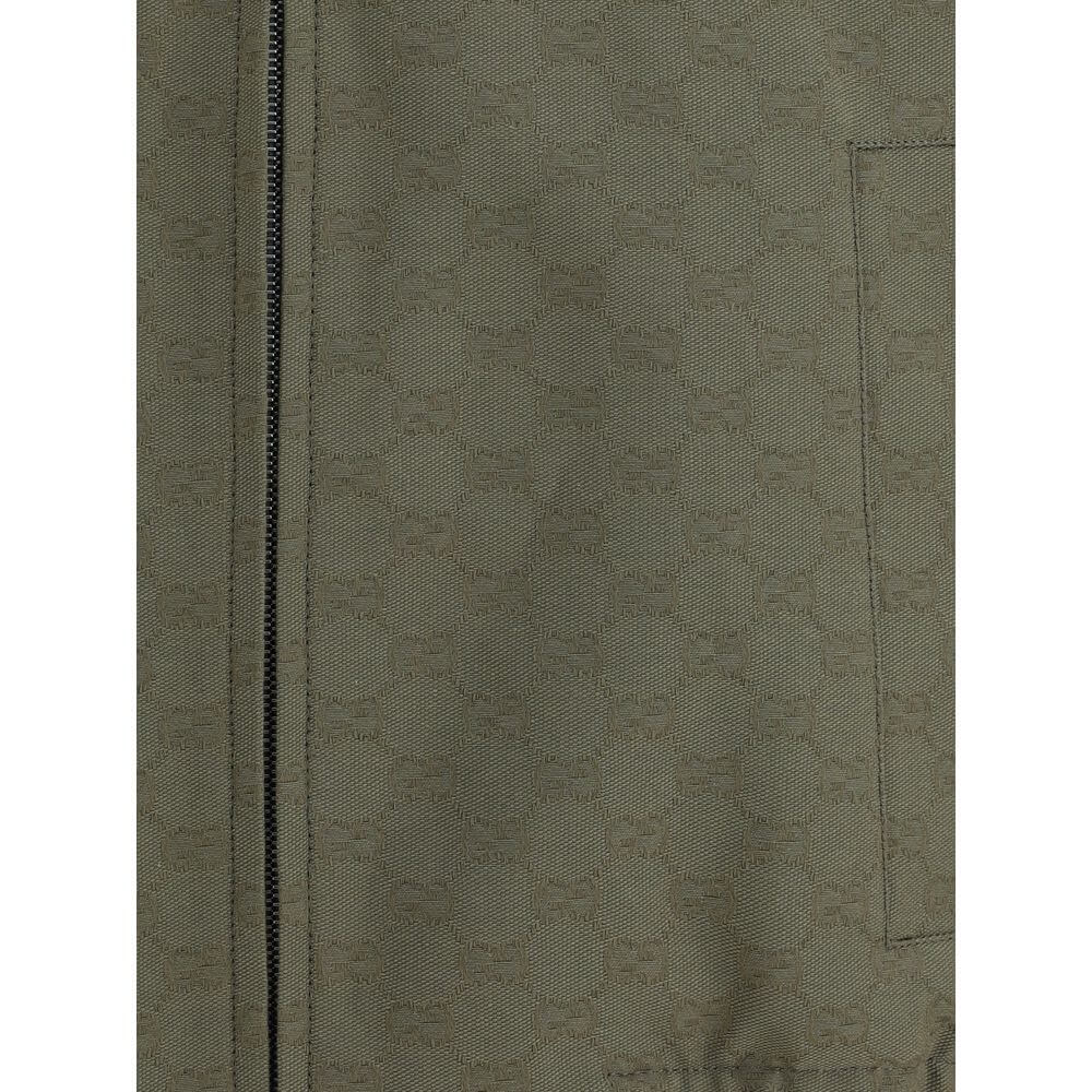 Close-up of Gucci Green Cotton Bomber with GG Supreme pattern, featuring a front zipper and pocket detail in a green cotton-polyester mix.