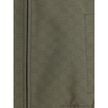 Close-up of Gucci Green Cotton Bomber with GG Supreme pattern, featuring a front zipper and pocket detail in a green cotton-polyester mix.