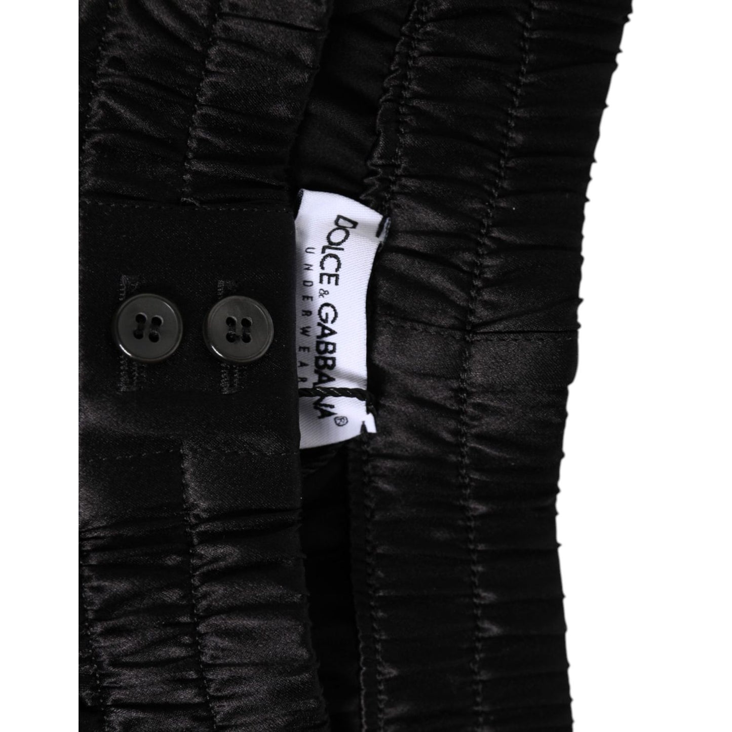 Close-up of Dolce & Gabbana Black Silk Satin Elastic Men Boxer Short Swimwear with button detail and logo.