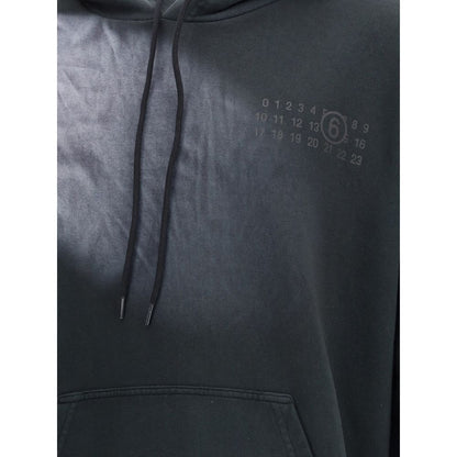 Close-up of MM6 Black Cotton Sweatshirt with logo, showcasing the kangaroo pocket and drawstring hood for a casual look.