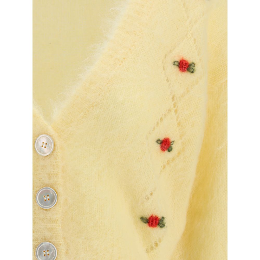 Close-up of Alessandra Rich Yellow Mohair Cardigan with floral embroidery, V-neckline, and button closure, showcasing delicate perforations.