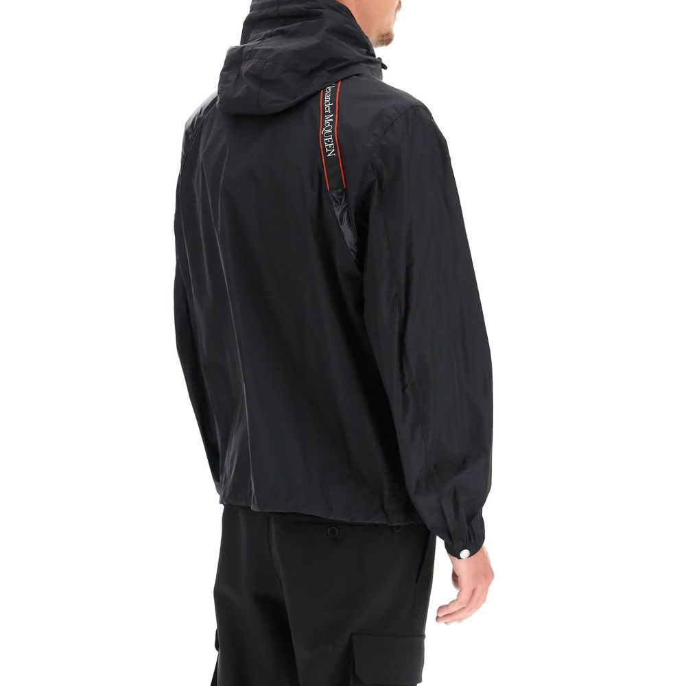 Man wearing Alexander McQueen Black Polyamide Shell Jacket with elasticated cuffs and shoulder selvage belt, back view.