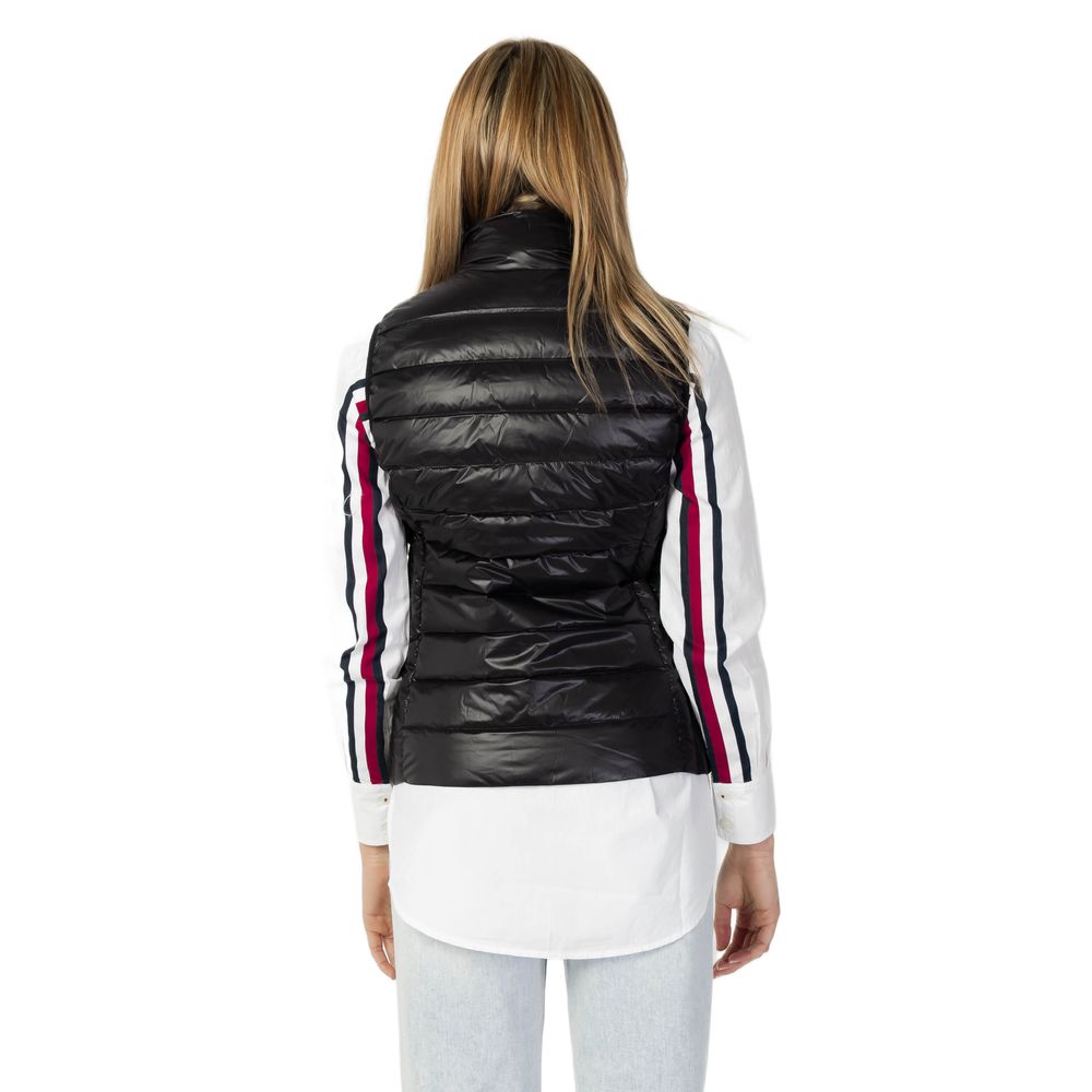 Back view of a woman wearing an Armani Exchange Black Polyester Sleeveless Jacket over a white shirt with striped sleeves.
