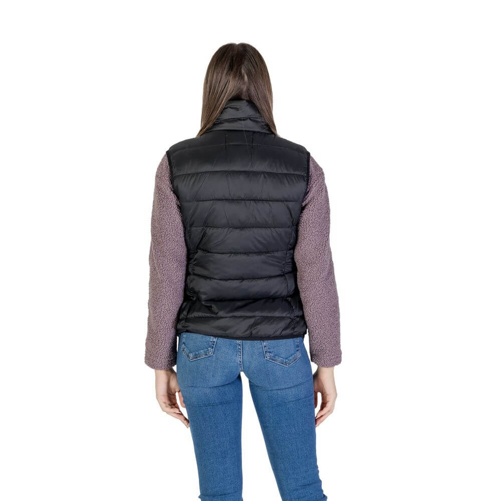 Rear view of a woman wearing a B.Young Black Nylon Sleeveless Jacket, showcasing the quilted design and sleek style.