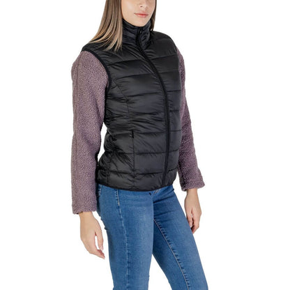 Woman wearing B.Young Black Nylon Sleveless Jacket with purple sleeves, showcasing quilted design and front zip closure for style and warmth.