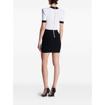 Back view of a white and black Balmain Two-tone twisted knit bodycon dress with rear zip fastening and black high heels.