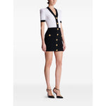 Balmain Two-tone twisted knit bodycon dress with V-neck, short sleeves, and rear zip fastening, modeled by a woman, thigh-length mini dress.