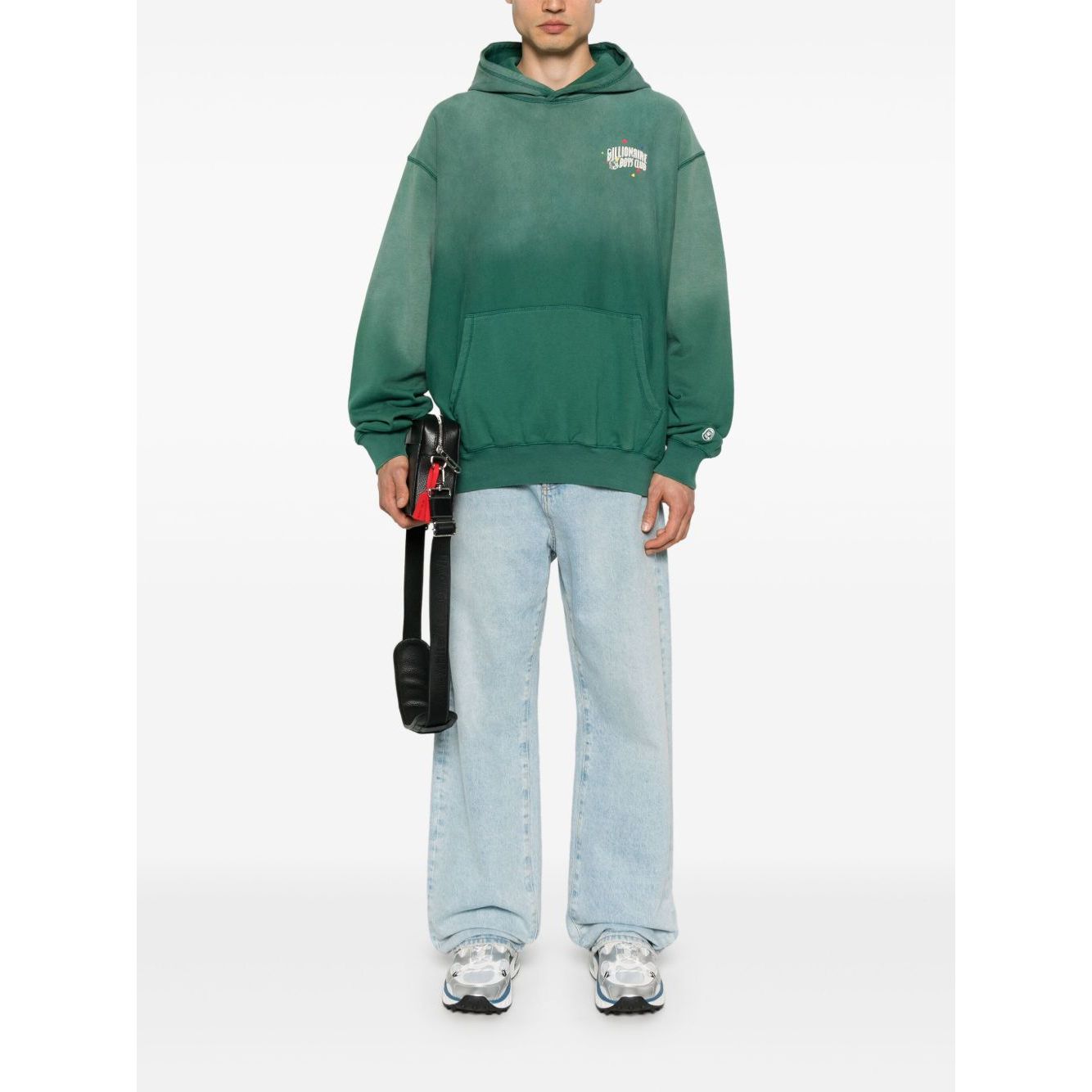 Billionaire Sweaters Green oversized hoodie with front pouch and logo patch, modeled by a person wearing light jeans and sneakers.