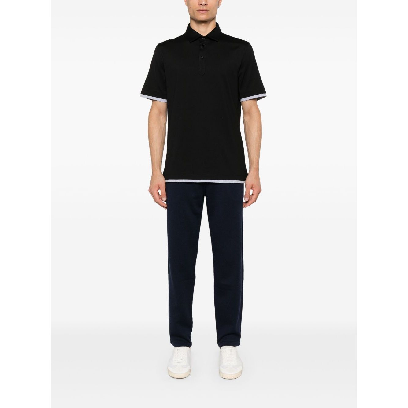 Model wearing Brunello Cucinelli Trousers Blue with elastic waistband and tapered legs, styled with a black polo shirt and white shoes.