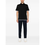 Model wearing Brunello Cucinelli Trousers Blue with elastic waistband and tapered legs, styled with a black polo shirt and white shoes.