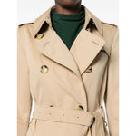 Burberry Double-breasted cotton trench coat in archive beige with epaulettes, storm flap, and adjustable waist belt.