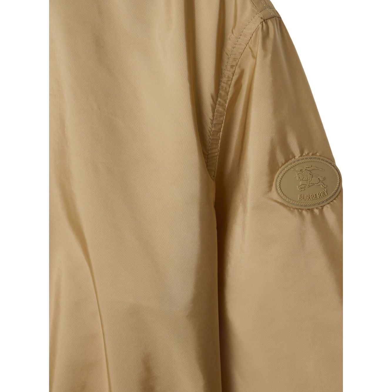 Close-up of Burberry Short nylon parka with check motif and logo badge on sleeve.