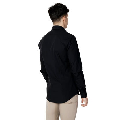 Rear view of man wearing Calvin Klein Black Cotton Dress Shirt, showcasing slim fit and minimalist design for modern style.