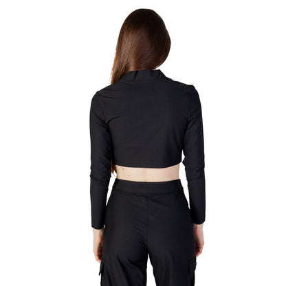 Back view of model wearing Calvin Klein Jeans Black Recycled Polyester Top with high collar and long sleeves, showing modern design.