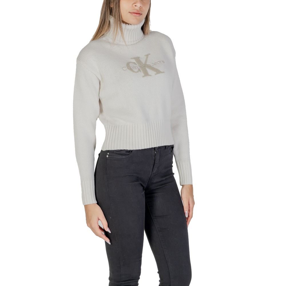 Woman wearing Calvin Klein Jeans Cream Cotton Sweater with CK logo and ribbed turtleneck, side view.