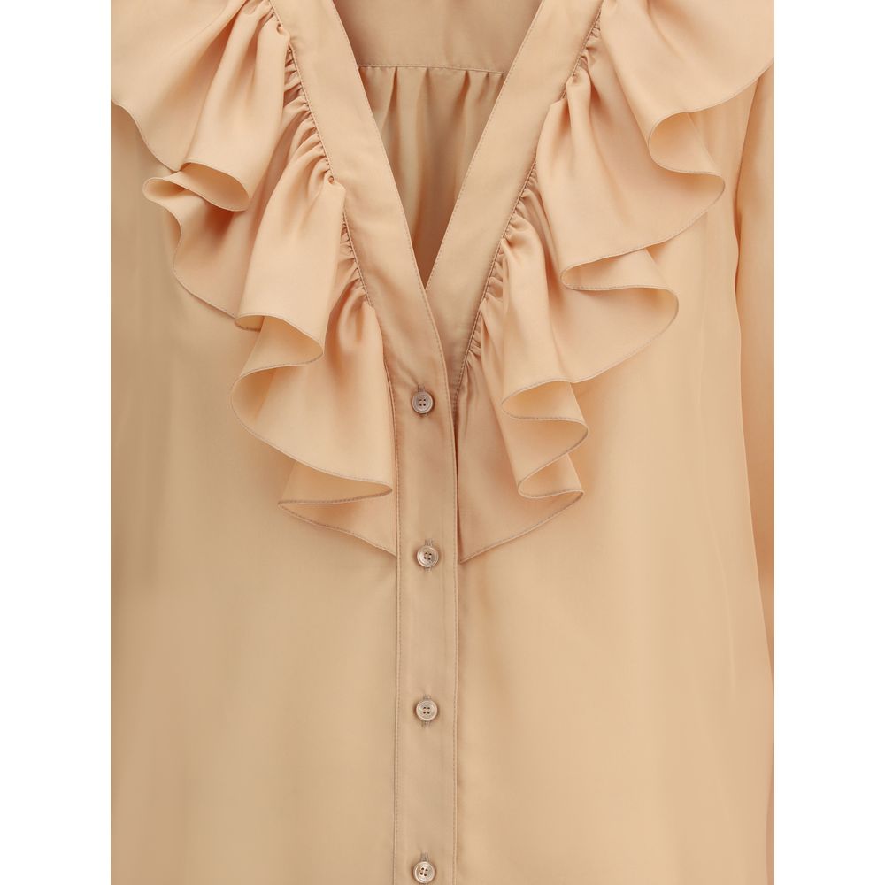Close-up of Chloé Ruffle Shirt in silk with V-neckline and ruffle details, featuring mother-of-pearl buttons. Elegant and feminine design.