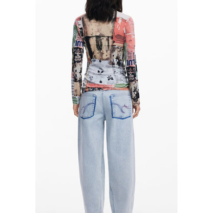 Back view of woman wearing colorful Desigual top and light blue jeans