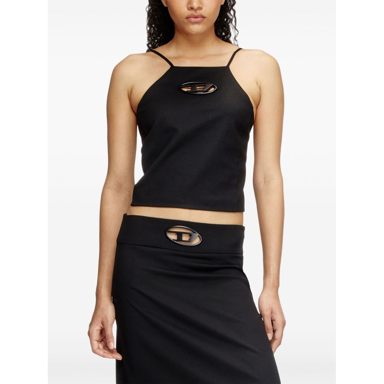 Woman wearing Diesel Top Black with a stretch-design, halterneck, and cropped straight hem, featuring D logo plaque and spaghetti straps.