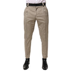 Dolce & Gabbana Beige Black Striped Cotton Slim Fit Trousers Pants on model, featuring tapered design and elegant vertical stripes.