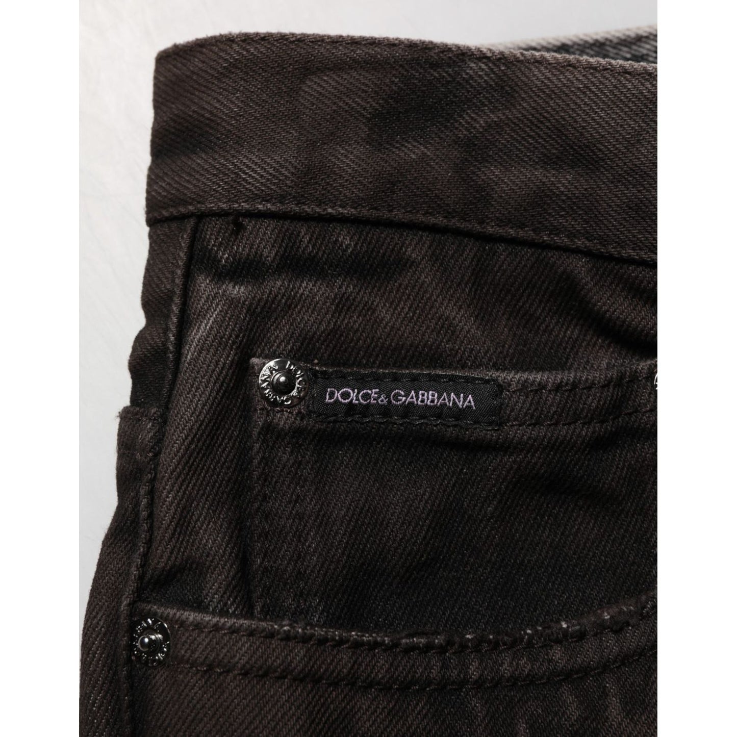 Dolce & Gabbana Black Cotton Tattered Denim Men Bermuda Short close-up with brand label and pocket detail.