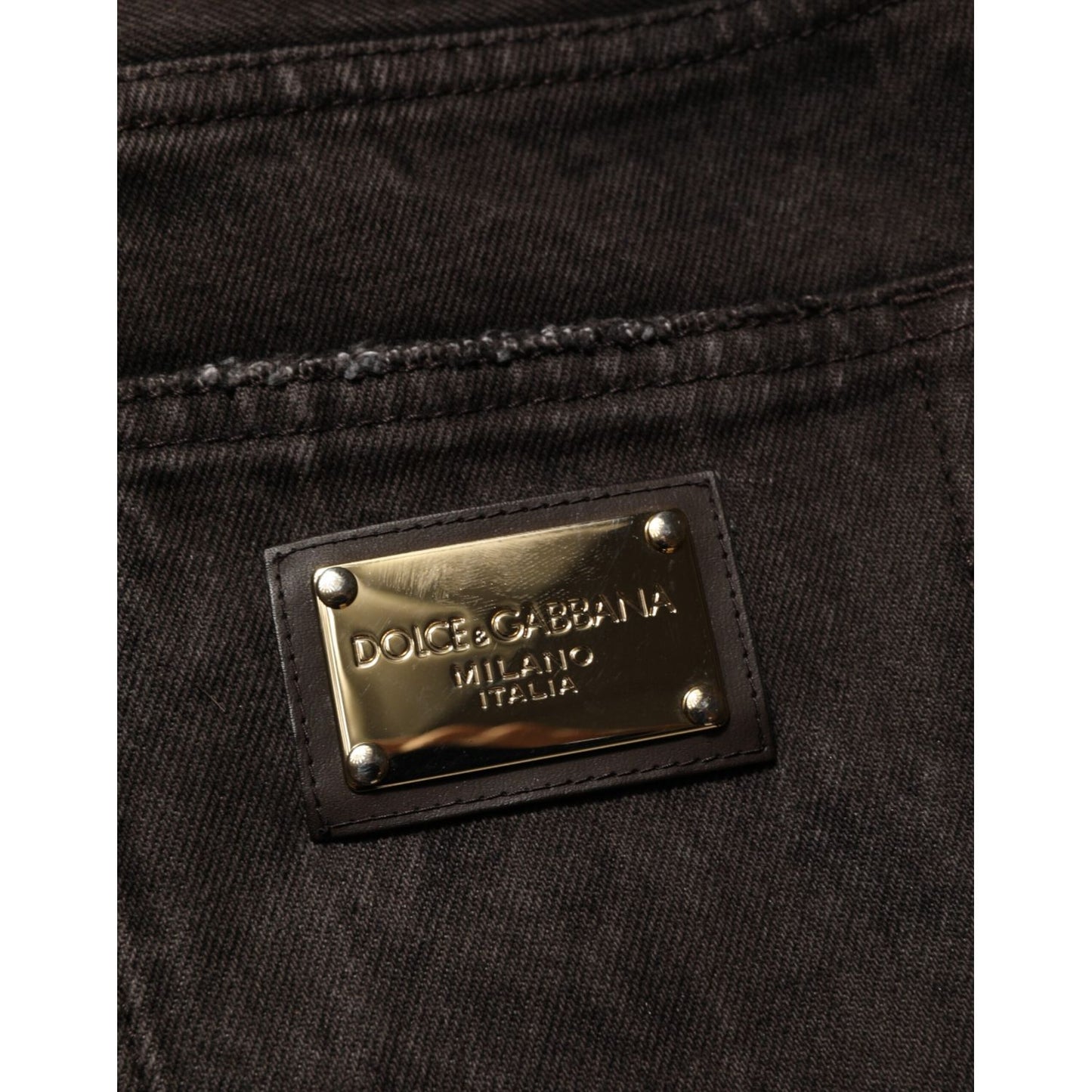 Close-up of Dolce & Gabbana Black Cotton Tattered Denim Men Bermuda Short with gold logo tag on pocket.