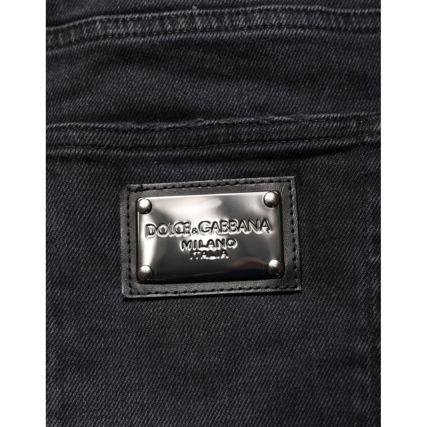 Close-up of Dolce & Gabbana Black Slim Fit Stretch Men Denim Pants Jeans label on black fabric.