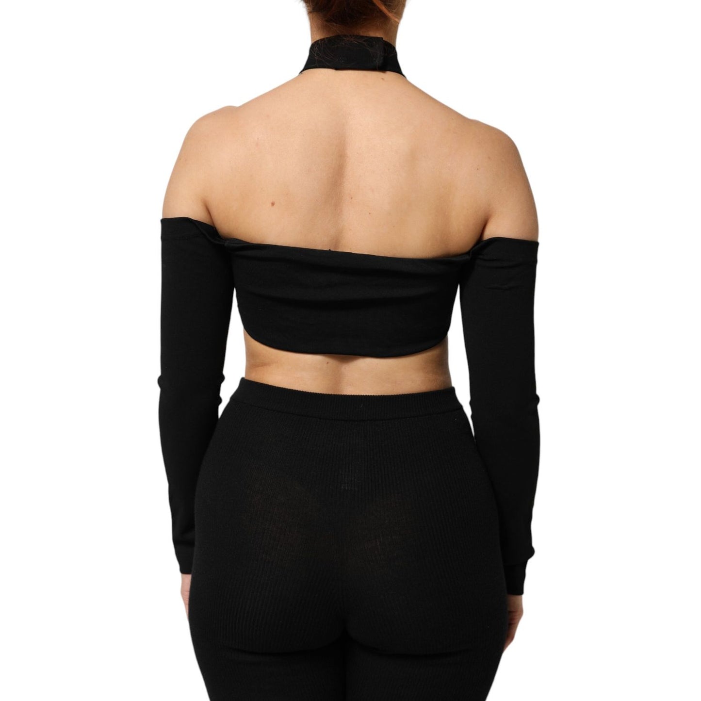 Back view of model wearing Dolce & Gabbana Black Viscose Halter Off Shoulder Cropped Top, highlighting off-shoulder design and halter neckline.