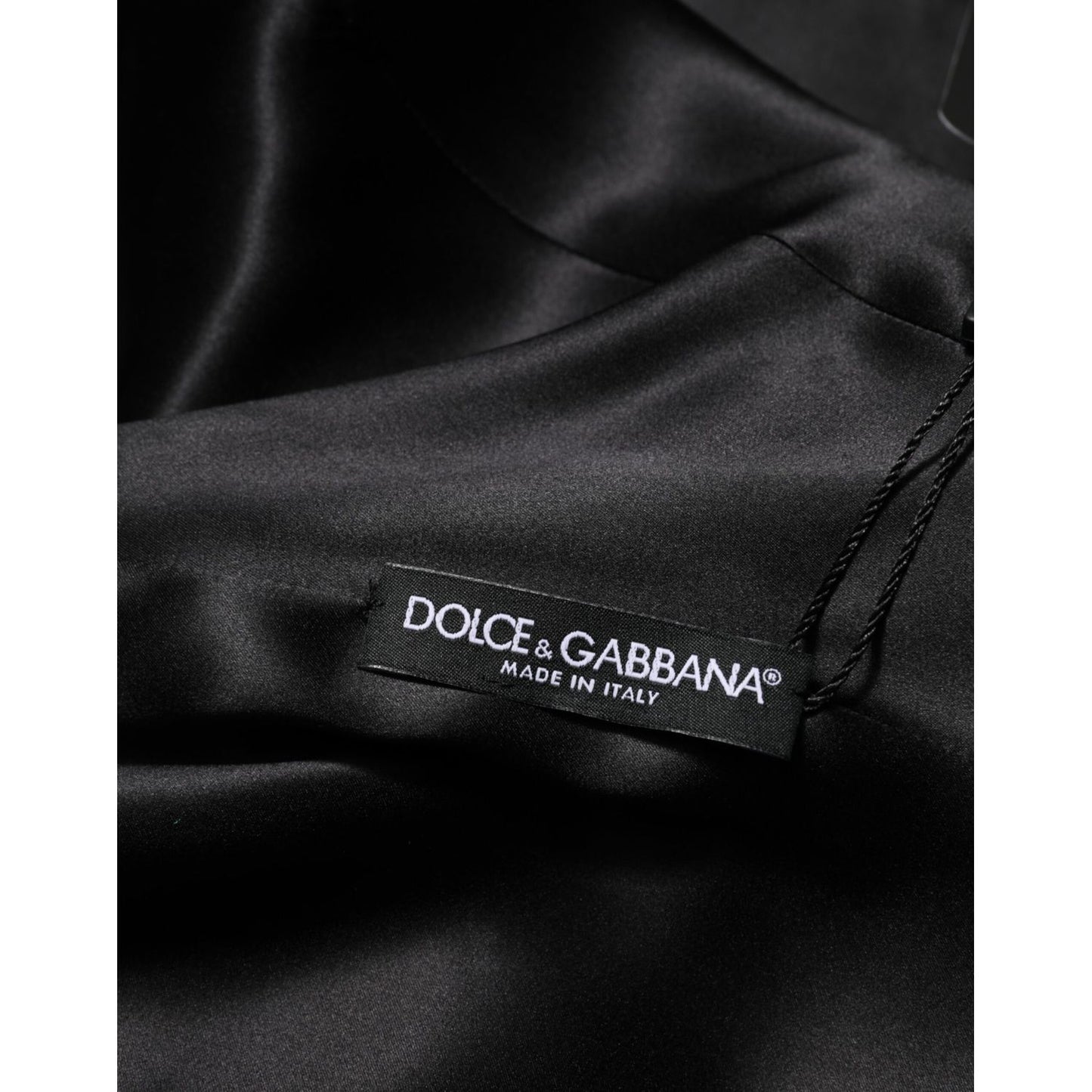 Close-up of Dolce & Gabbana label on the green viscose acetate mini long sleeve dress, showcasing quality craftsmanship from Italy.