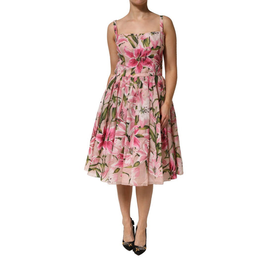 Woman wearing Dolce & Gabbana Pink Floral Lily Print Midi Sleeveless Dress, square neckline, pleated skirt, perfect for summer events.