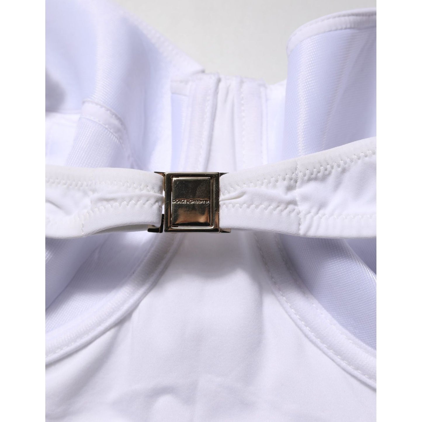 Dolce & Gabbana White Padded Balconette One Piece Swimwear close-up with logo detail, featuring a sleek white fabric and gold clasp.