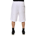 Model wearing Dolce & Gabbana White Ripped Mid Waist Casual Bermuda Short, showcasing back view and ripped style details.