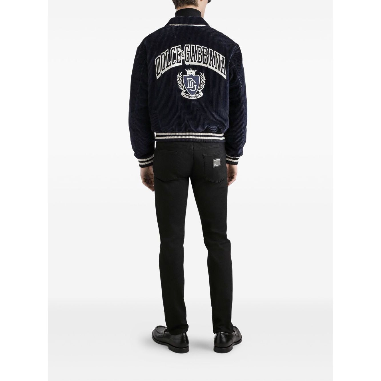 Back view of man wearing Dolce & Gabbana five pockets logo plaque Denim cotton jeans, black with classic design and logo plaque detail.