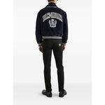 Back view of man wearing Dolce & Gabbana five pockets logo plaque Denim cotton jeans, black with classic design and logo plaque detail.