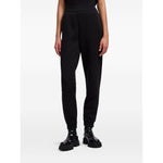 Woman wearing EMPORIO ARMANI CAPSULE Trousers Black with elastic waistband and ribbed ankles.