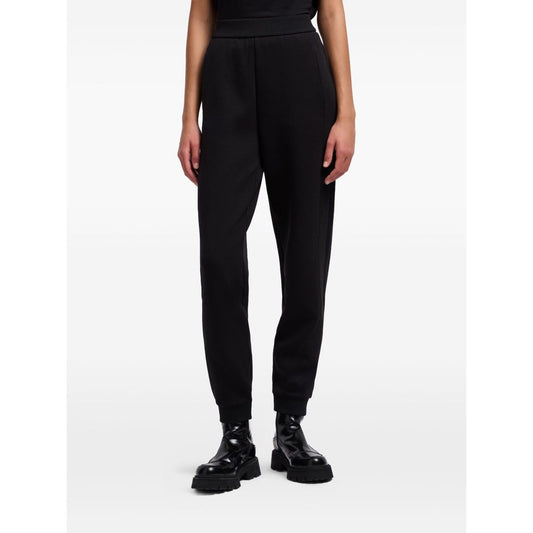 Woman wearing EMPORIO ARMANI CAPSULE Trousers Black with elastic waistband and ribbed ankles.