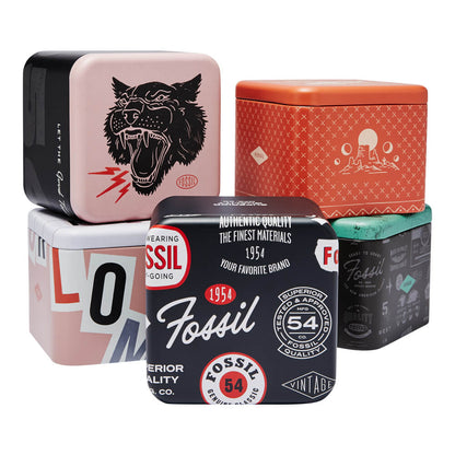 Stack of colorful Fossil watch packaging tins showcasing retro designs and vintage logos.