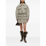 Model wearing GANNI Jackets Beige, light tweed with front button fastening, two chest pockets, frayed detailing, and pointed collar.