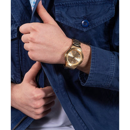 Gent wearing GUESS Mod. GW0454G2 quartz analog watch with a gold dial and silver band, 44mm case, water resistant to 5 ATM
