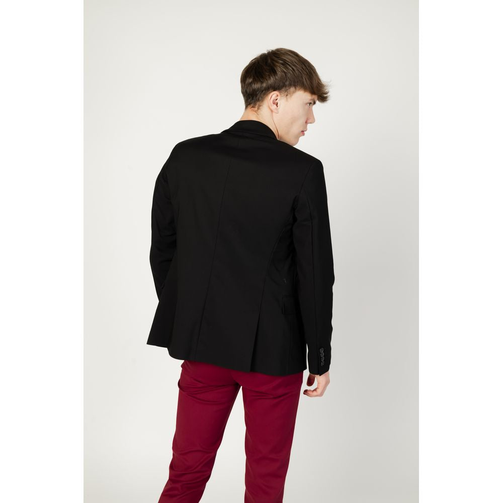 Man wearing Gianni Lupo Black Cotton Blazer from the back, paired with red pants, exhibiting modern and refined style.