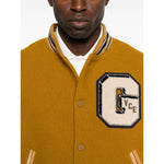 Golden Goose Coats: mustard yellow bomber jacket with leather sleeves, varsity-style patches, ribbed trims, and welt pockets.