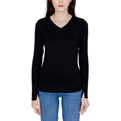 Woman wearing Guess Black Cotton Sweatshirt with V-neck and buttoned sleeves, paired with blue jeans, showcasing elegant and casual style.