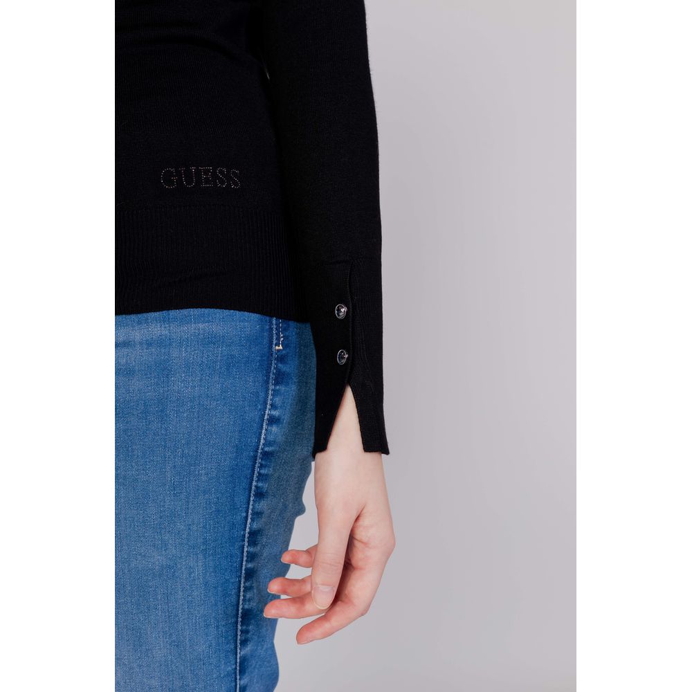 Woman wearing Guess Black Cotton Sweatshirt with decorative button sleeves, paired with blue jeans, showcasing modern casual style.